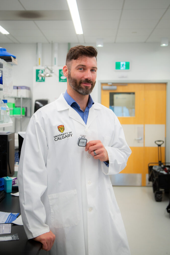 Dr. Dustin Pearson holding a radon test kit (Credit: Glynnis Mutch Photography)